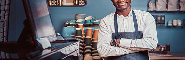 Micro entrepreneur souriant dans son commerce de café
